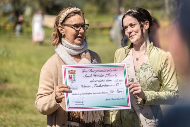 Baumblütenkönigin Doreen überreicht einen Spendencheck der Stadt Werder