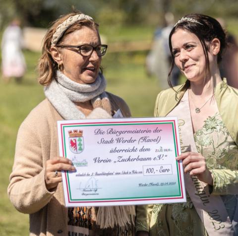 Baumblütenkönigin Doreen überreicht einen Spendencheck der Stadt Werder